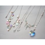 Five contemporary white metal pendant necklaces, including one Art Nouveau style necklace set with