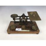 A set of Victorian brass postal scales and weights, on oak platform base bearing ivory plaque