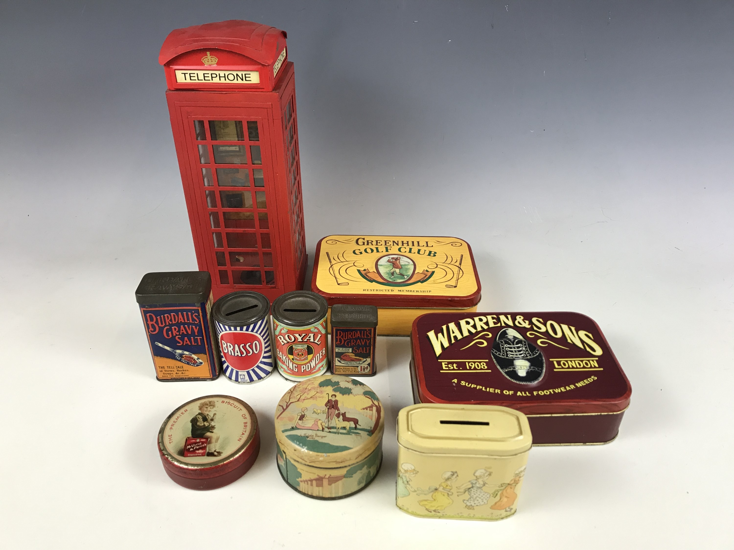 Various advertising tins together with a telephone money box