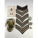 Sundry military collectors' items including a Manchester Regiment silk postcard, rank, unit and