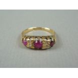 An early 20th Century ruby, diamond and 18ct gold dress ring, the face claw set with three graded