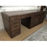 An uncommonly long mahogany office kneehole desk, comprising a conventional arrangement of two banks