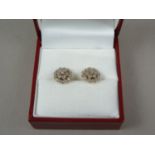 A pair of diamond stud earrings, pellet set in an open cluster arrangement on yellow metal,