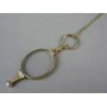 An early 20th Century rolled gold lorgnette, with engraved decoration, on a rolled-gold neck chain