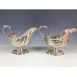 An impressive pair of early George V silver sauce boats, of helmet form, each having sweeping