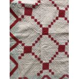 An early 20th Century patchwork quilt, in a geometric diaper design incorporating red cotton over