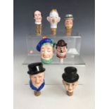 Seven vintage continental porcelain novelty bottle stoppers and spouts, modelled as the heads of