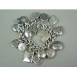 A vintage silver charm bracelet and padlock clasp adorned with a collection of silver and white