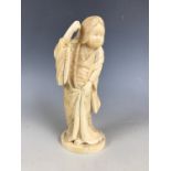 A Meiji Japanese carved marine ivory okimono depicting a jolly woman wearing her hair in a