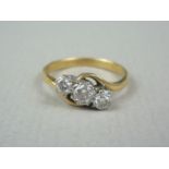 A vintage three stone diamond ring, in a graded arrangement of brilliant cut stones, the central