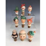 Nine vintage German porcelain novelty bottle stoppers and spouts, modelled as the heads of various