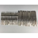 A set of twelve Edwardian silver fruit knives and forks, foliate engraved with mother of pearl