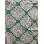 An early 20th Century patchwork quilt, in a geometric diaper design incorporating mint green and