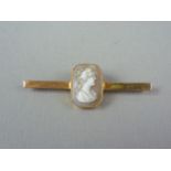 An early 20th Century yellow metal and shell cameo bar brooch, the latter carved in depiction of a