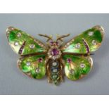 A Belle Epoch ruby and diamond insect brooch modelled as an emerald green butterfly, the thorax claw