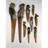 Nine Black Forest type novelty bookmarks and letter openers, the terminals carved and painted with