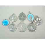 Eight vintage silver and white metal religious iconographic pendants, including two basse-taille