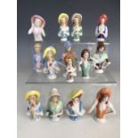 Fourteen vintage continental porcelain pin-cushion ladies wearing period fashion and poke bonnets