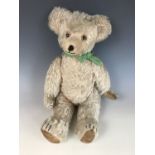 A 1930s Teddy bear, with wood wool stuffing, articulated limbs, blonde mohair, velvet lined pads and