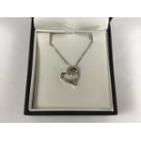 A contemporary 9ct white gold and diamond heart shaped pendant necklace, retailed by Ernest Jones,