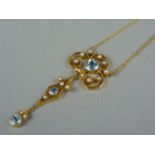 An Edwardian aquamarine and seed pearl open-work pendant necklace, comprising a trefoil scroll, set
