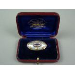 A late 19th / early 20th Century Art Nouveau amethyst and mother of pearl brooch, having a