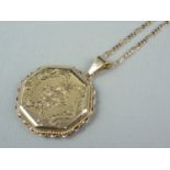 A contemporary 9ct gold pendant locket, of hexagonal section with foliate engraved decoration, on