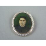 An early 20th Century diamond locket brooch, containing the hand tinted photographic portrait of