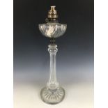 A late Victorian cut glass oil lamp, the reservoir supported on a faceted hollow-blown baluster