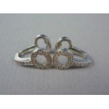 A pair of contemporary diamond and high carat precious white metal (tested as 18ct gold) earrings,