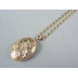 A 9ct gold pendant double locket, with foliate engraved decoration, on a yellow-metal belcher link
