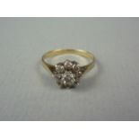 A diamond flower head cluster dress ring, the central stone of approximately .16ct, surrounded by