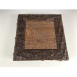 A carved mahogany jewellery or sewing box, the lid having a central square panel, relief-carved in