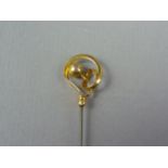 An early 20th Century 9ct gold Charles Horner hat pin, the terminal in a ribbon and ball