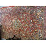 Tabriz rug with lobe medallion and all-over floral design on a red ground with borders,