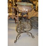 Late 19th / early 20th Century embossed copper jardiniere on an ornate wrought iron stand