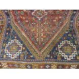 Shiraz rug with a single medallion and all-over stylised floral design on a red ground with blue