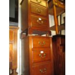 Pair of walnut three drawer bedside cabinets on bracket supports