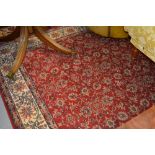 Machine woven Persian design carpet with floral pattern on red ground together with another similar