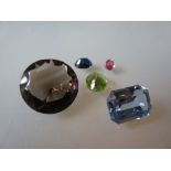 Group of five unmounted gem stones including peridot, synthetic spinel,