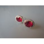 Pair of yellow gold oval treated ruby and diamond cluster ear studs, the rubies approximately 4.