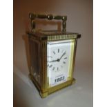 20th Century brass cased carriage clock with enamel dial having Roman numerals and winding key