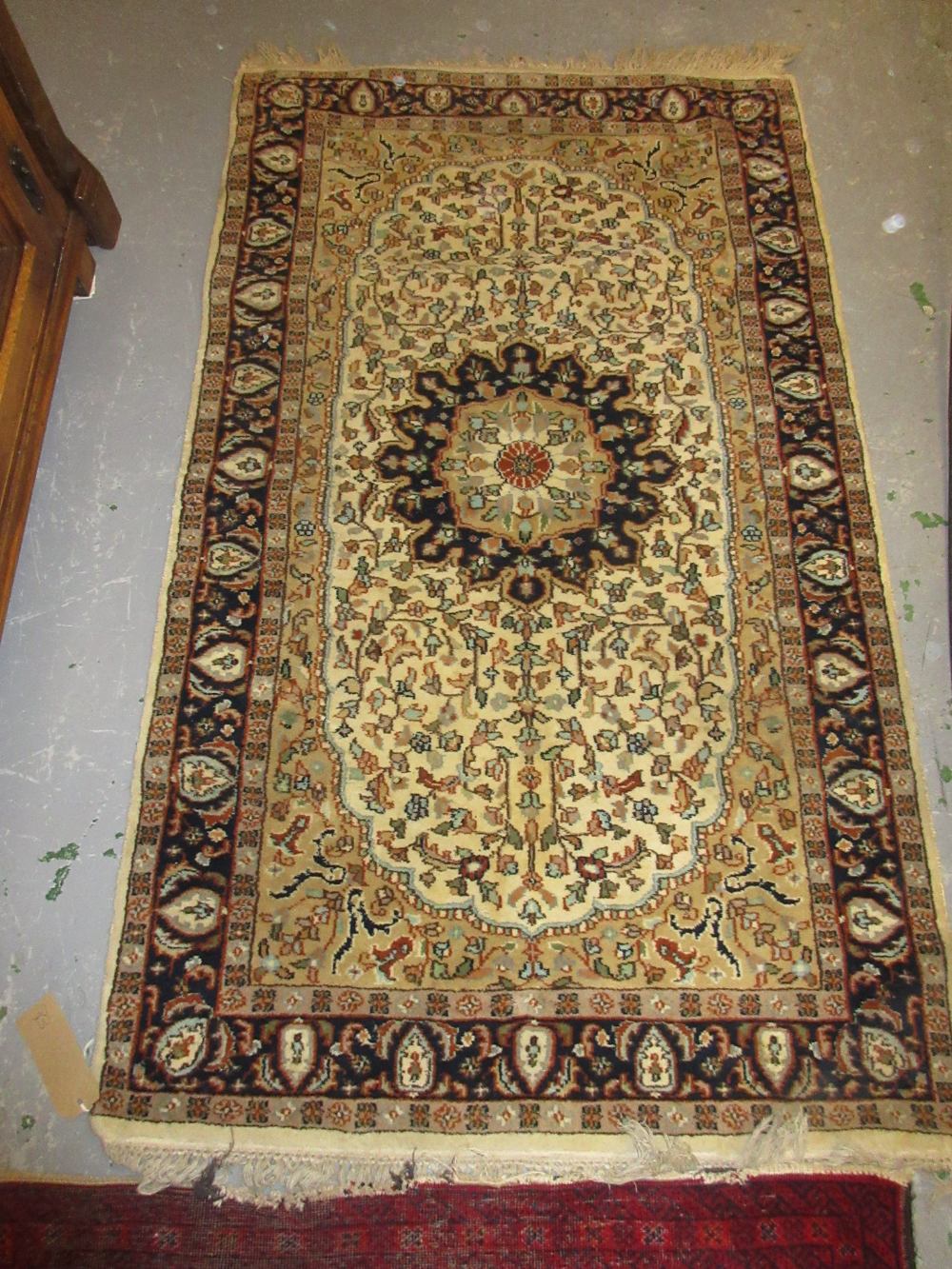 Small Indo Persian rug with medallion and floral design on an ivory ground together with a small
