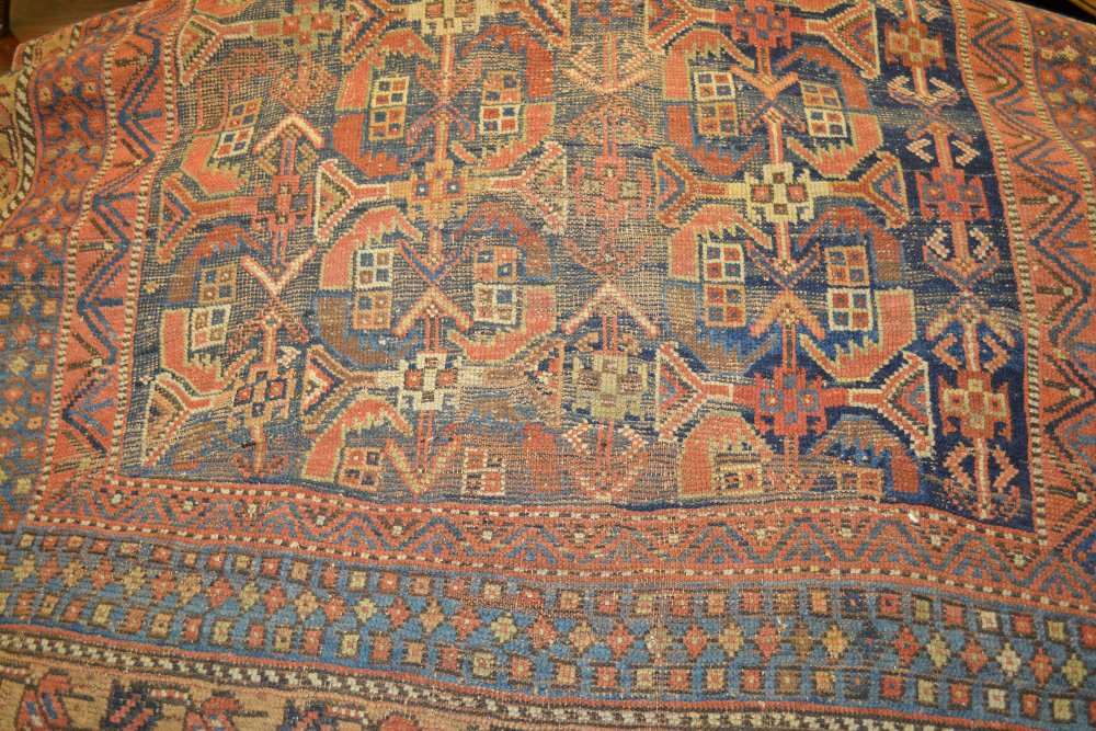 Kurdish rug with polychrome all-over design on a blue ground together with a small belouch rug