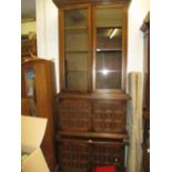 Pair of reproduction oak bookcases with a pair of glazed doors above panel doors together with a