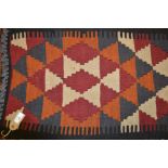 Kelim table runner with geometric design on burgundy, white, blue and orange ground, 17.