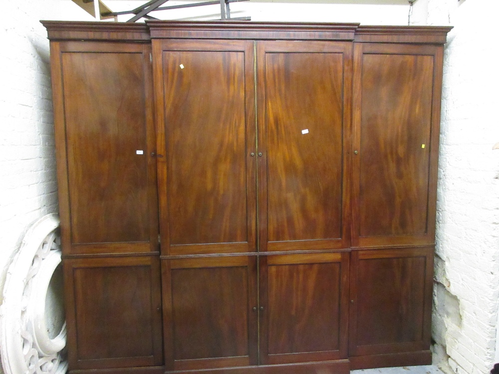 George III mahogany breakfront wardrobe with six panelled doors enclosing drawers and hanging space