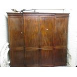 George III mahogany breakfront wardrobe with six panelled doors enclosing drawers and hanging space