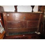 Antique oak coffer having two plank hinged top with two panel front with simple carved decoration