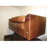 Similar smaller mid tan leather upholstered two seat sofa with a matching footstool